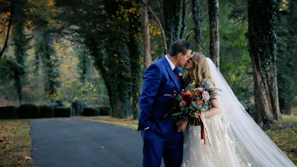 bride and groom kissing between a row of tree at Poplar Springs Manor
