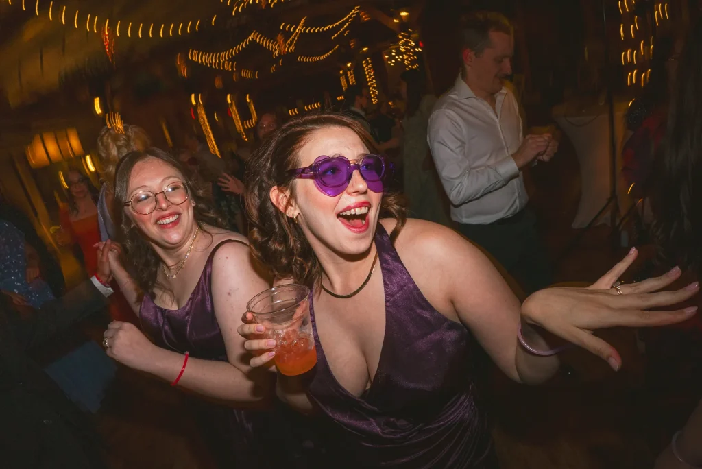 bridesmaids smiling on the dance floor at yellow barn